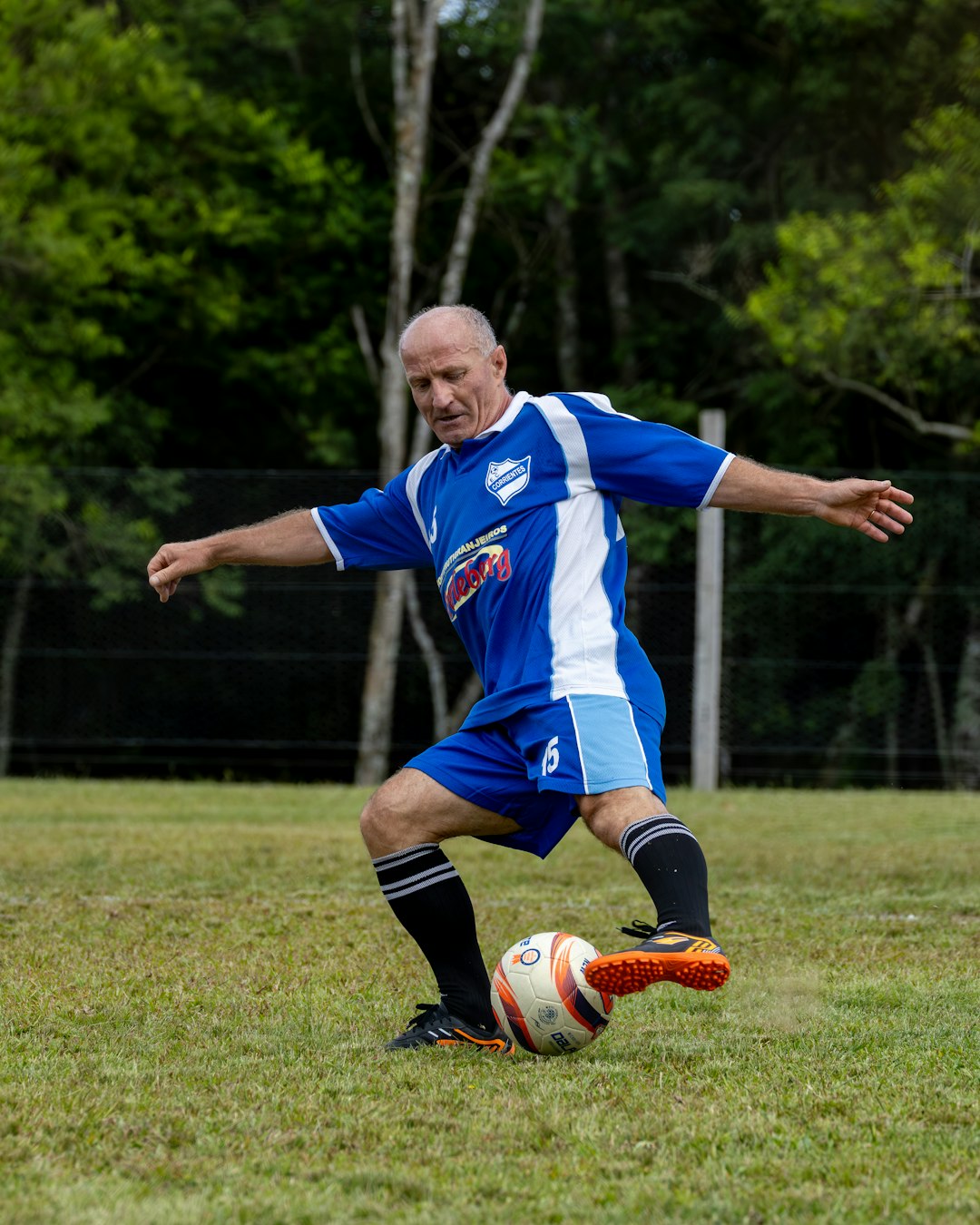 man-in-blue-soccer-uniform-kicking-ball-on-grassy-field-iyyc97qsy6m